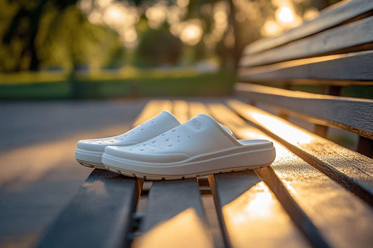 Chaussures blanches posées sur un banc en bois au soleil couchant