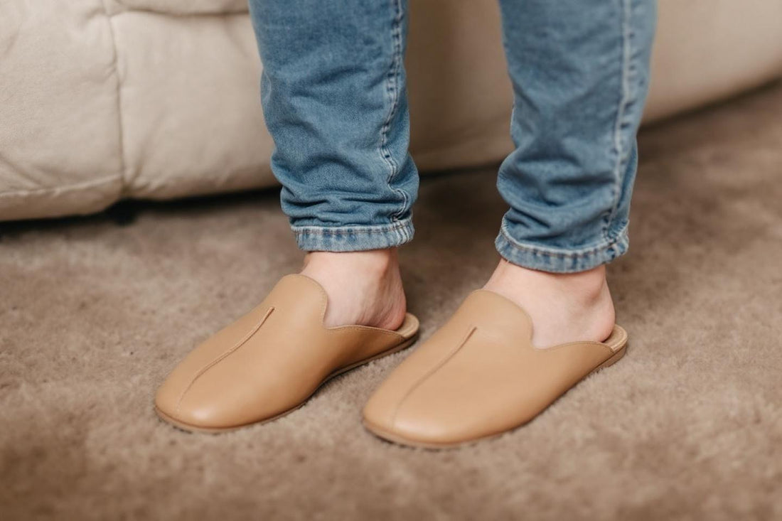 Pieds portant des mules en cuir nude et jean délavé